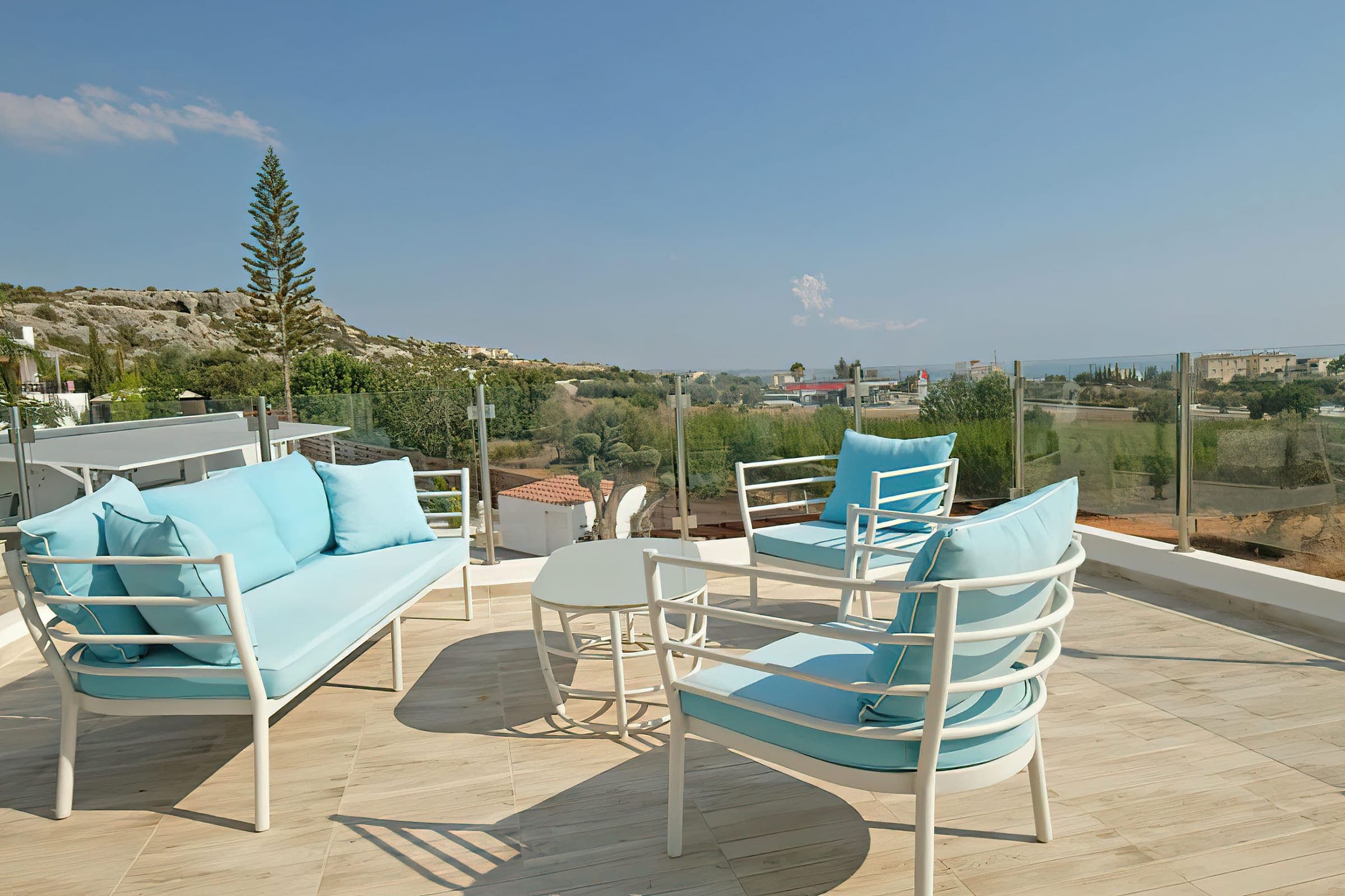 Balcony lounge with blue cushions and views over Peyia to the sea