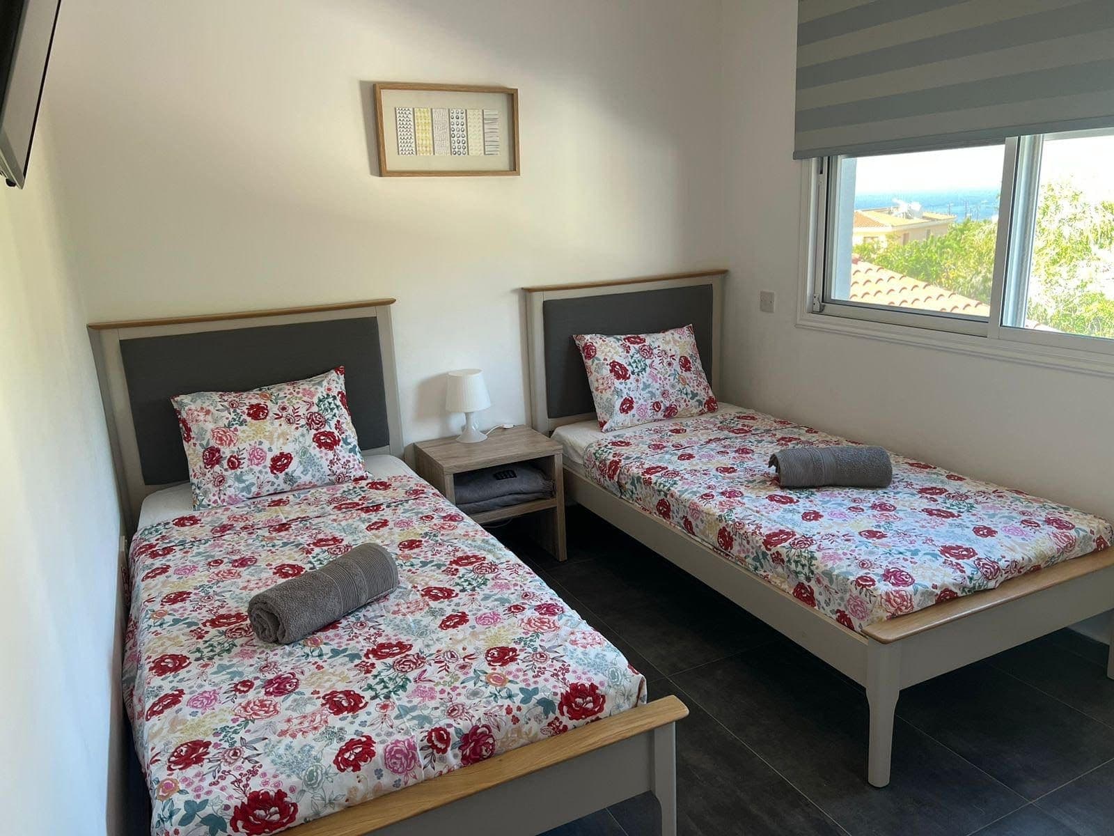 Twin bedroom with two single beds and a window with sea view