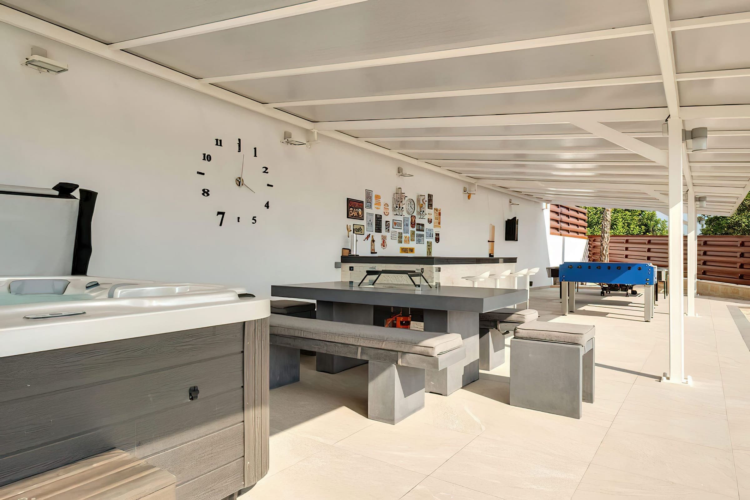 Covered outdoor dining and games area next to the hot tub