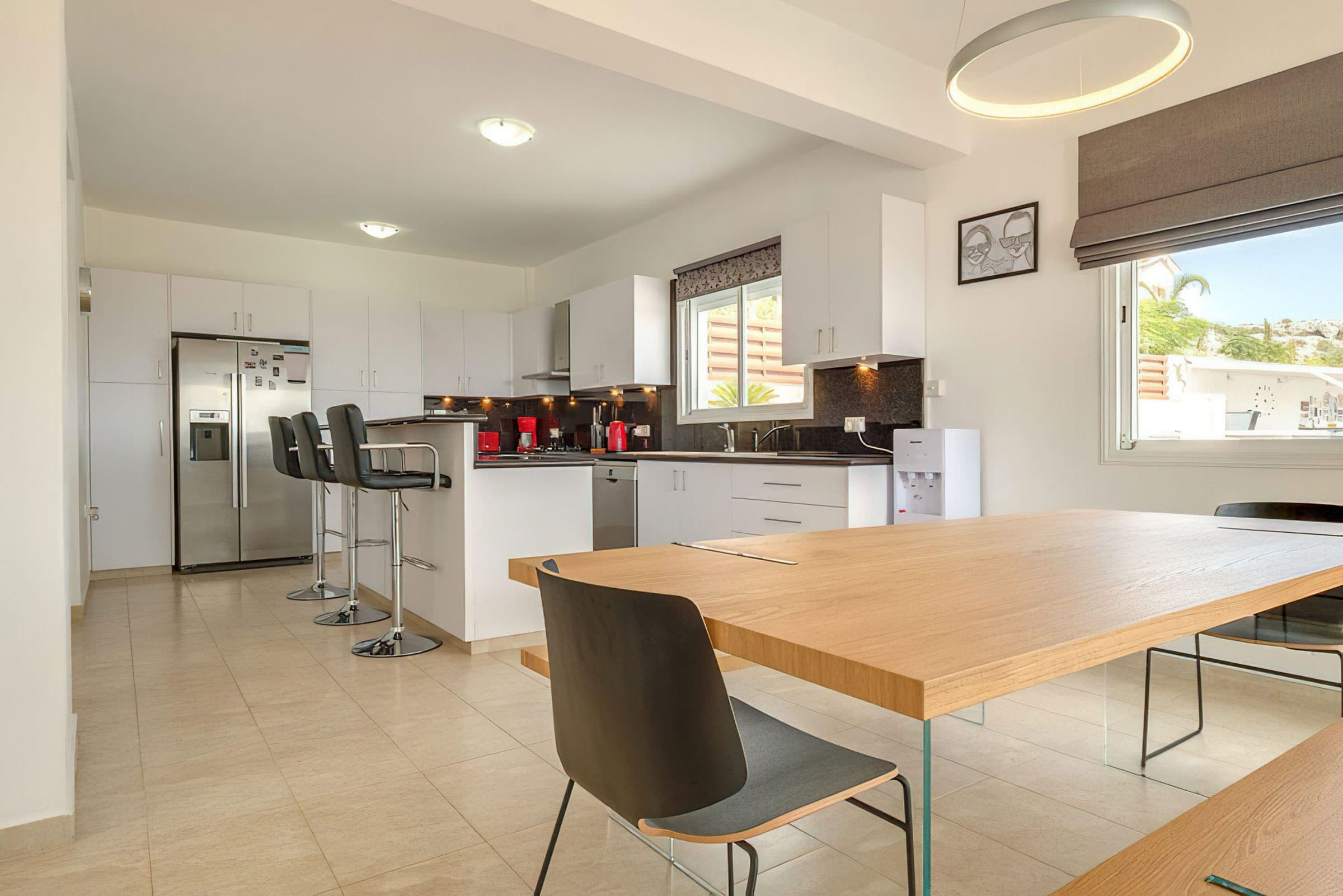 Modern kitchen with American fridge-freezer, breakfast bar and dining table