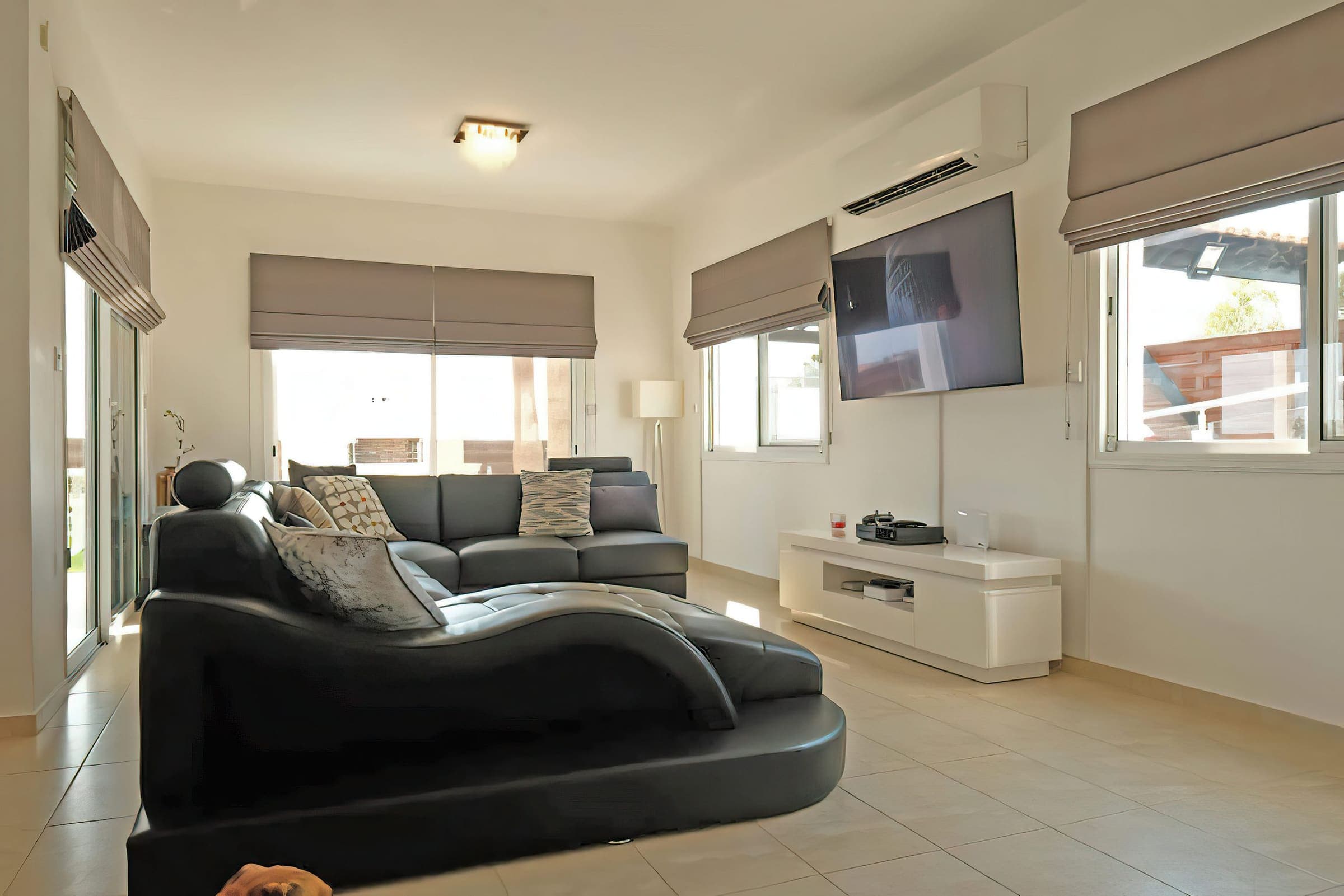 Open-plan living room with leather corner sofa and wall-mounted smart TV
