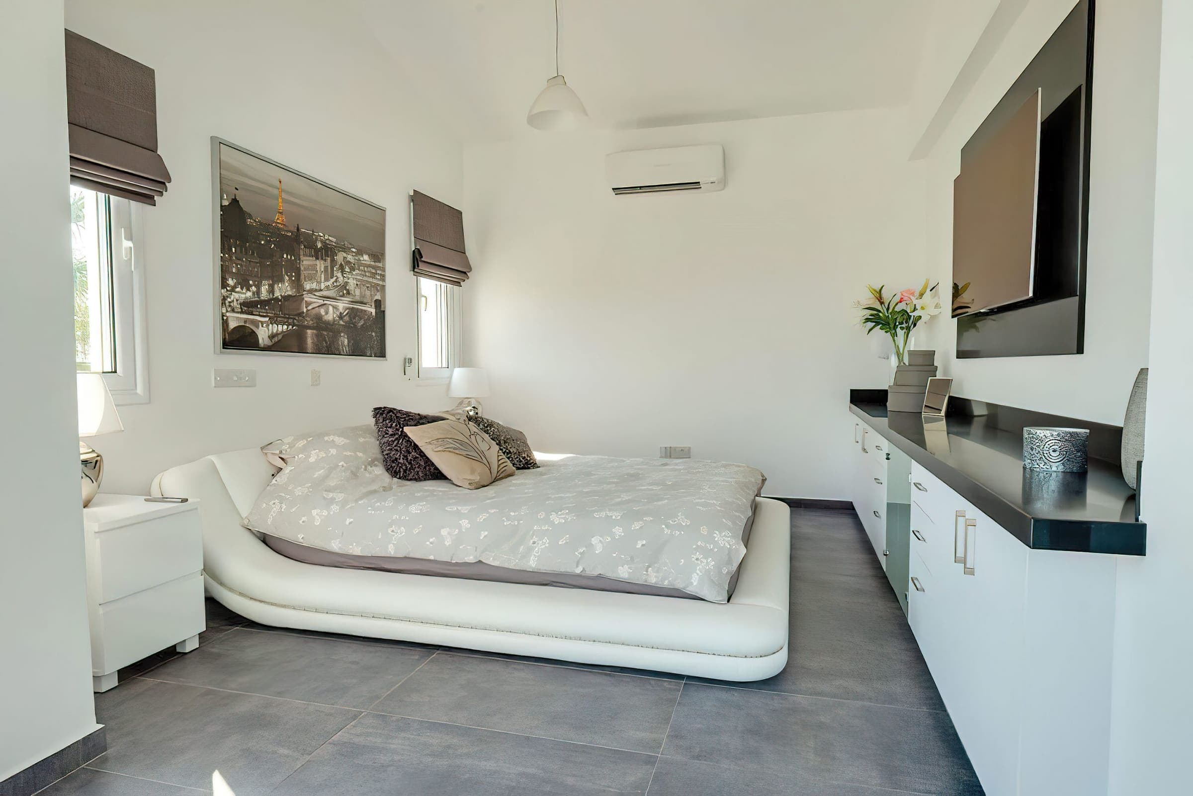 Master bedroom with platform double bed, wall TV and air conditioning