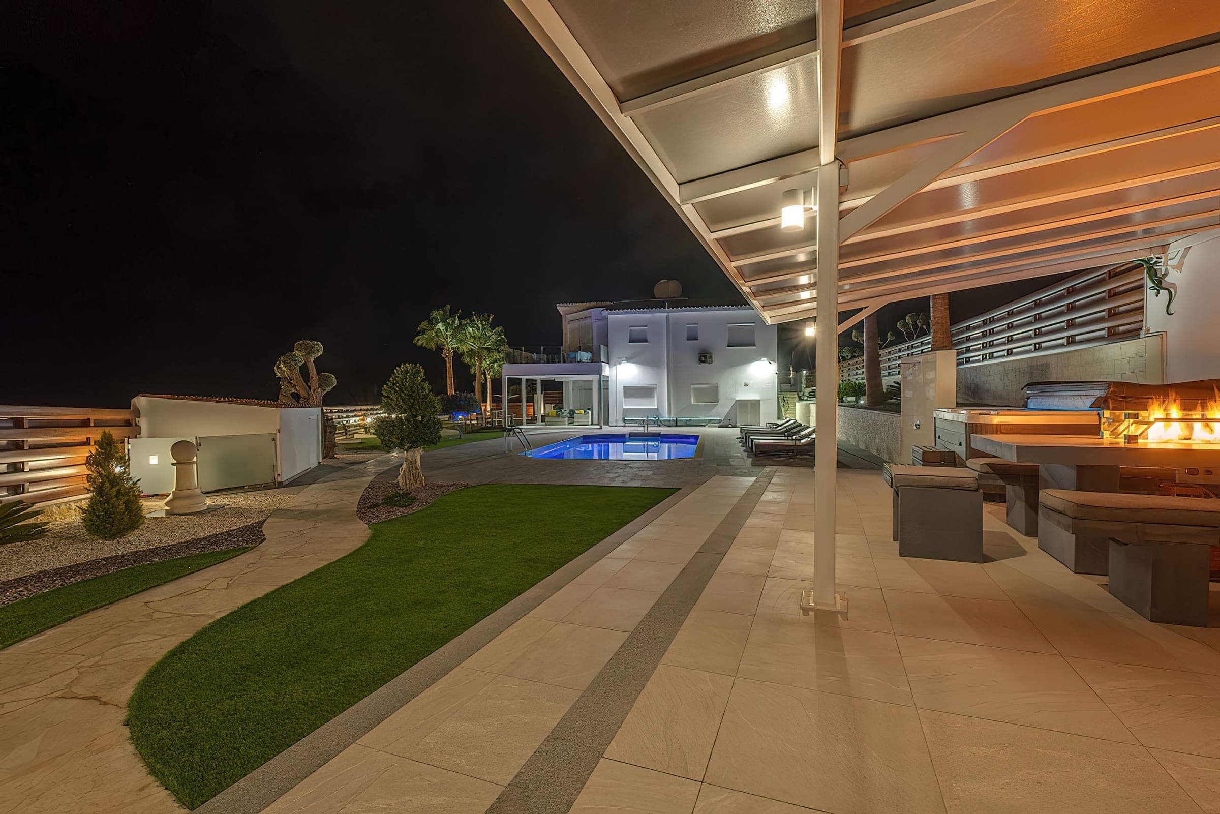 Lit pool and covered terrace in the evening