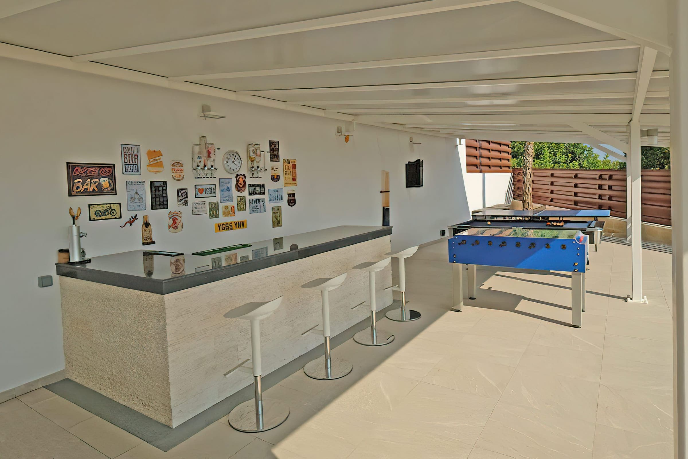 Outdoor bar with stools next to the table football