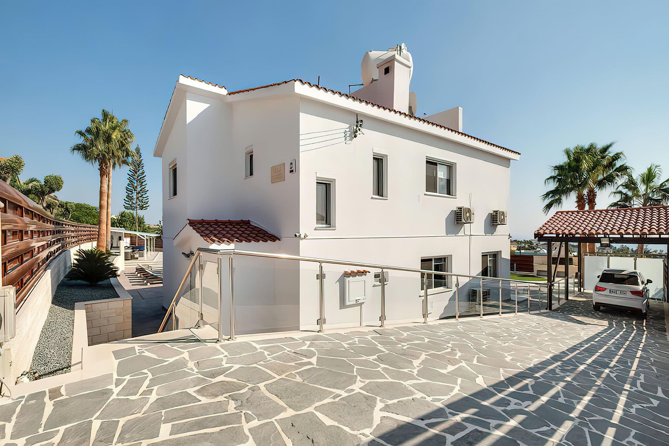 Villa entrance with gated private driveway and covered parking