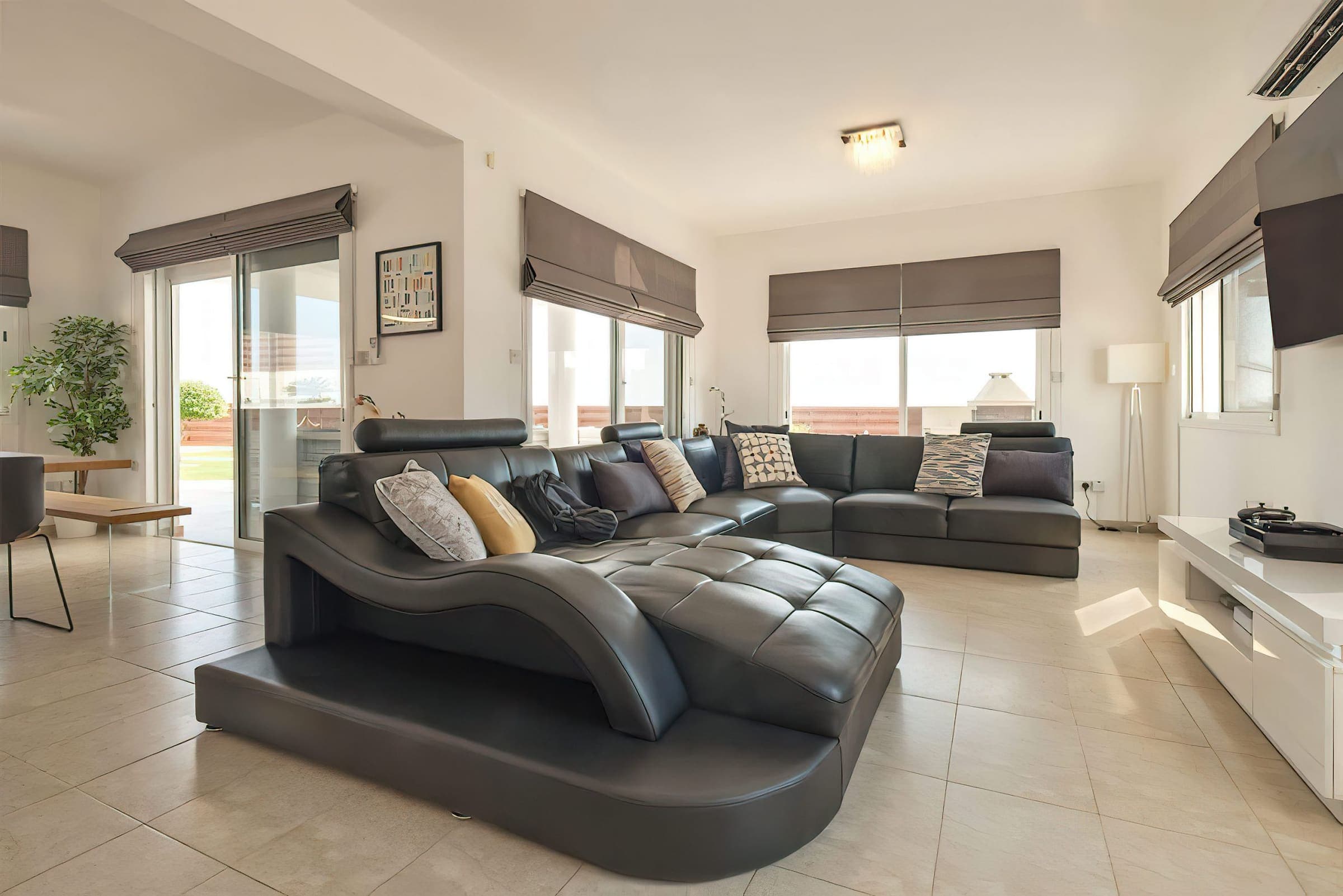 Bright lounge with a large leather corner sofa and patio doors